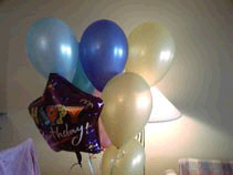 A bunch of balloons including a star shaped one saying Happy Birthday