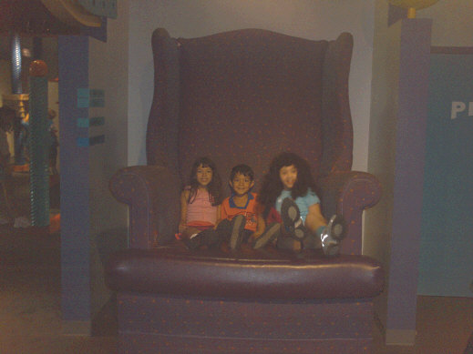 Victoria, Ian and Miranda sit in a giant chair.