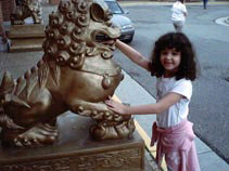 Miranda putting her hand in the mouth of a stylized lion