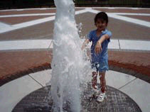 Miranda playing in a fountain